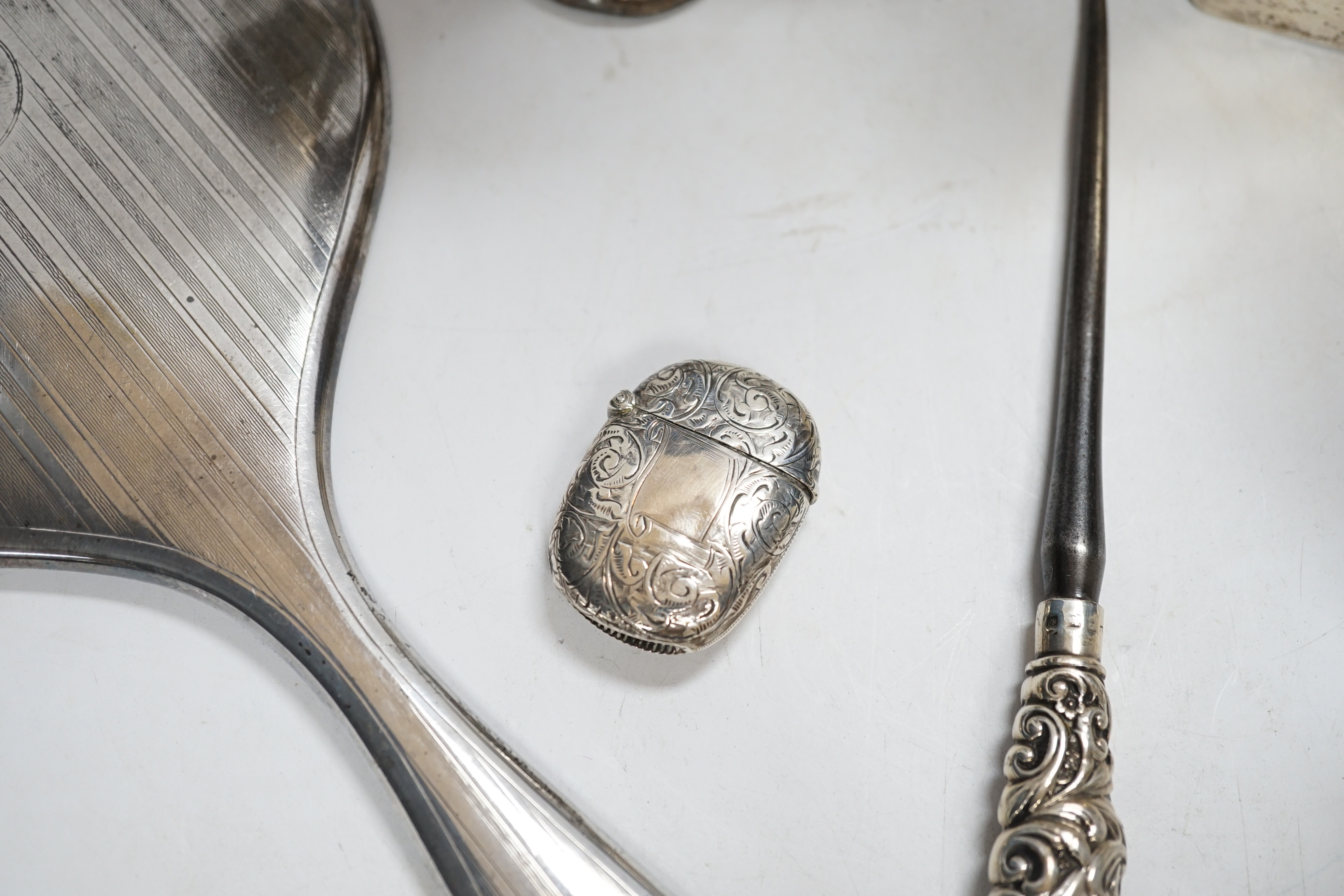 Sundry small silver including a silver mounted cigarette box, four assorted mounted glass toilet jars, a vesta case, button hook, hand mirror and trumpet vase.